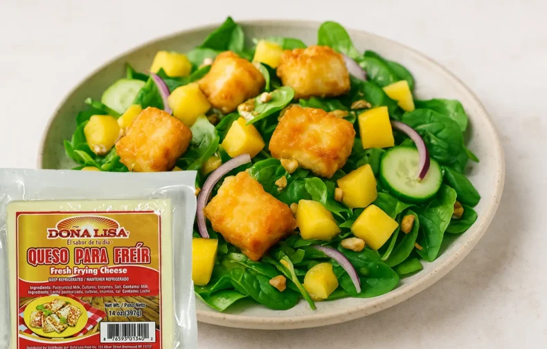 Ensalada tropical fresca con trozos de queso para freír Doña Lisa dorados, acompañada de frutas, lechuga y aderezo ligero.